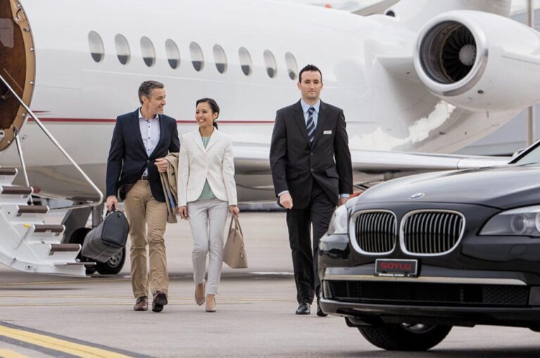 Business travelers walking from a private jet to a luxury car, showcasing reliable and premium Airport Transportation Services for comfortable and secure airport transfers.