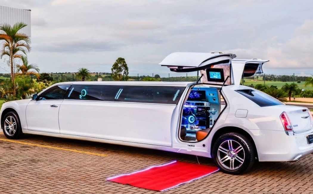 White stretch limousine with open gullwing door revealing a high-tech interior and red carpet setup, perfect for Special Event Rides.